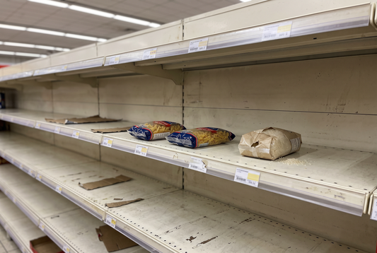 Nästan tom butikshylla med några få pastapaket