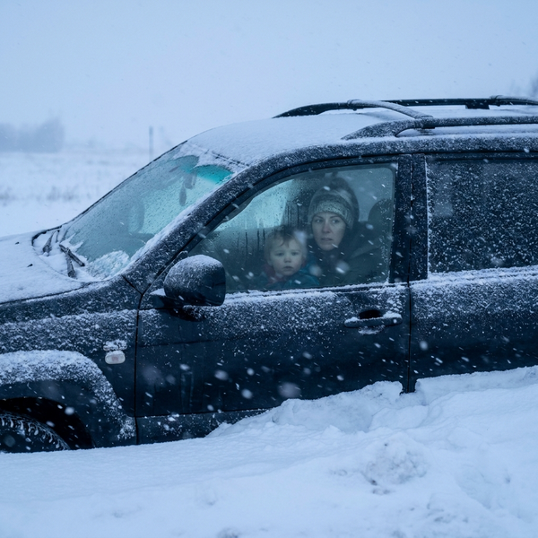 Mamma och barn i insnöad bil